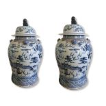 A PAIR OF 20TH CENTURY CHINESE BLUE AND WHITE VASES AND COVERS Decorated in Qianlong style with