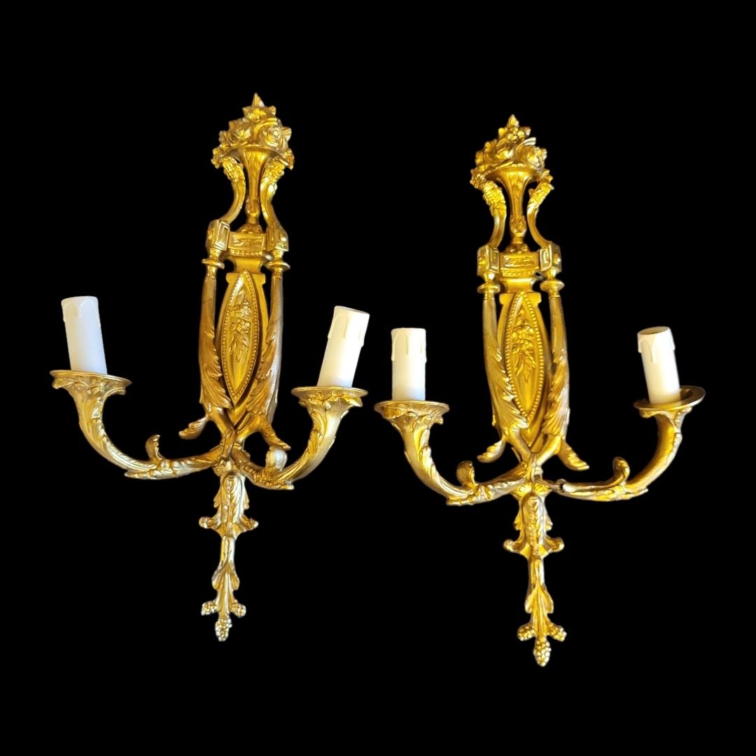 A PAIR OF 20TH CENTURY GILT BRONZE TWIN BRANCH WALL SCONCES Neoclassical shape applied with