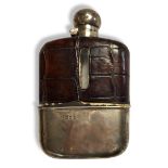 A VICTORIAN SILVER AND CROCODILE SKIN HIP FLASK Having a screw cap, the glass bottle clad with