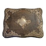 A VICTORIAN SILVER AND LEATHER DESK BLOTTER Scrolled form, with applied pierced silver cartouches,
