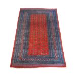 A BOKHARA WOOLLEN RUG Having bird form motifs to central field and three running borders. (approx