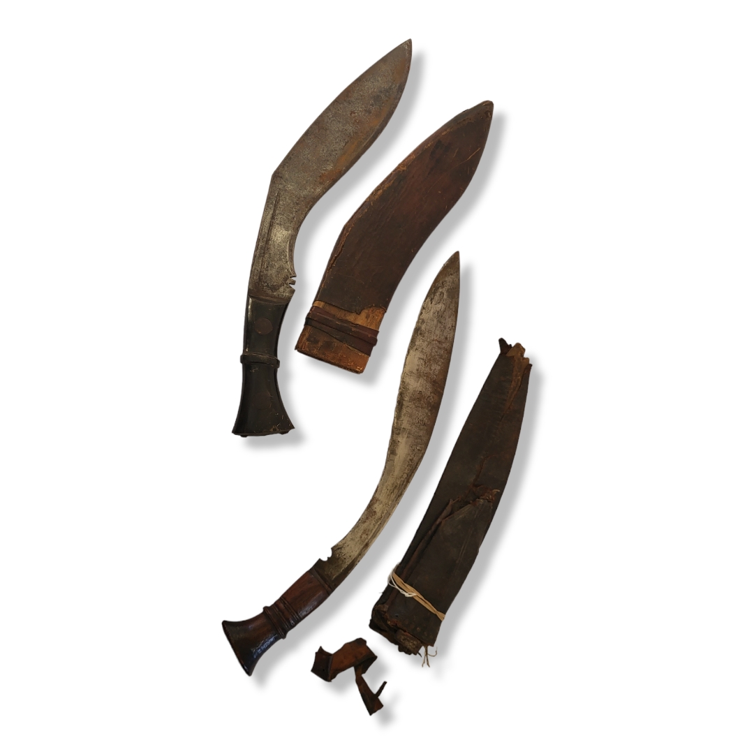 TWO EARLY 20TH CENTURY GHURKA 'KHUKURI' MILITARY KNIVES Having carved wooden handles, steel blades