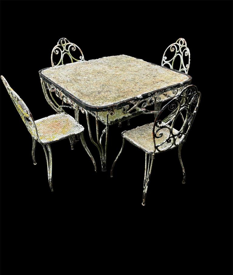 AN EARLY 20TH CENTURY WROUGHT IRON AND PIERCED STEEL GARDEN TABLE AND FOUR CHAIRS With scrollwork