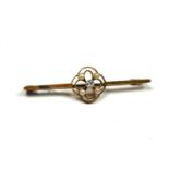 AN EARLY 20TH CENTURY 15CT GOLD, DIAMOND AND SEED PEARL BAR BROOCH The central round cut diamond
