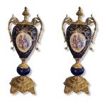 A PAIR OF 20TH CENTURY DECORATIVE SÈVRES STYLE GILT METAL MOUNTED PORCELAIN URNS AND COVERS Both