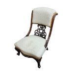A VICTORIAN MAHOGANY NURSING CHAIR With scroll back, fretwork panelled, fabric upholstery, on