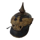 A WWI GERMANY MILITARY PICKELHAUBE HELMET Having an outer canvas cover marked ‘RIII’, a brass spike,