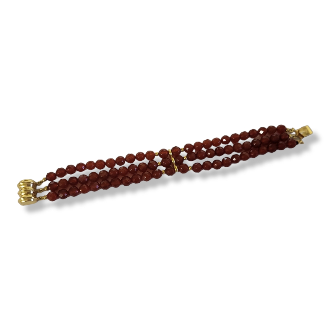 AN 18CT GOLD AND AMBER COLOURED HARDSTONE BRACELET Three strands of faceted beads. Condition: good