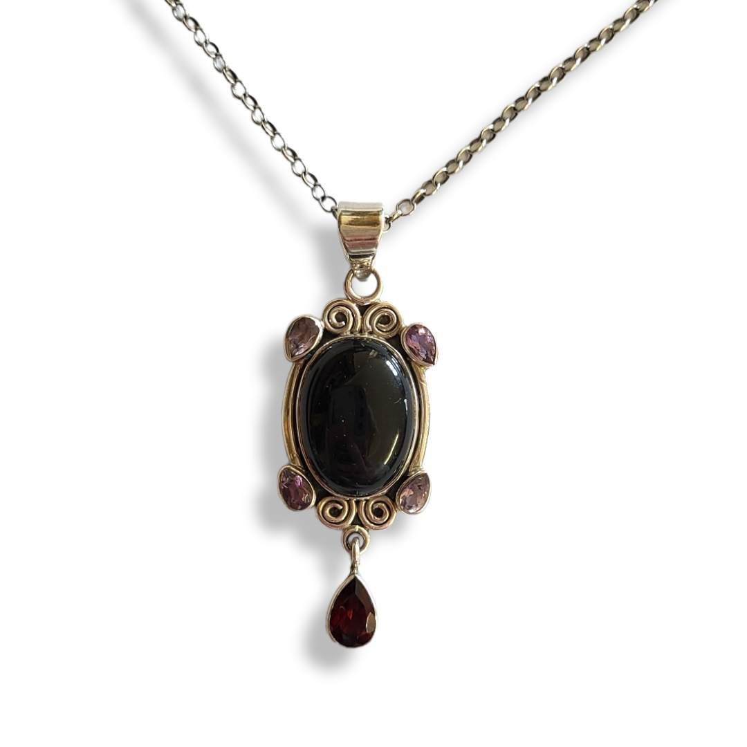A SILVER AND GEM PENDANT NECKLACE The oval cut central stone with pear cut amethyst and garnet drop,