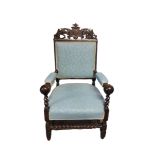 AN ANTIQUE OAK OPEN ARMCHAIR With carved and pierced top rail, upholstered back and seat, on