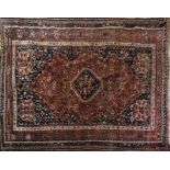 AN INDIAN/PERSIAN WOOLLEN RUG Woven with exotic birds and scrolls on a lozenge form central field on