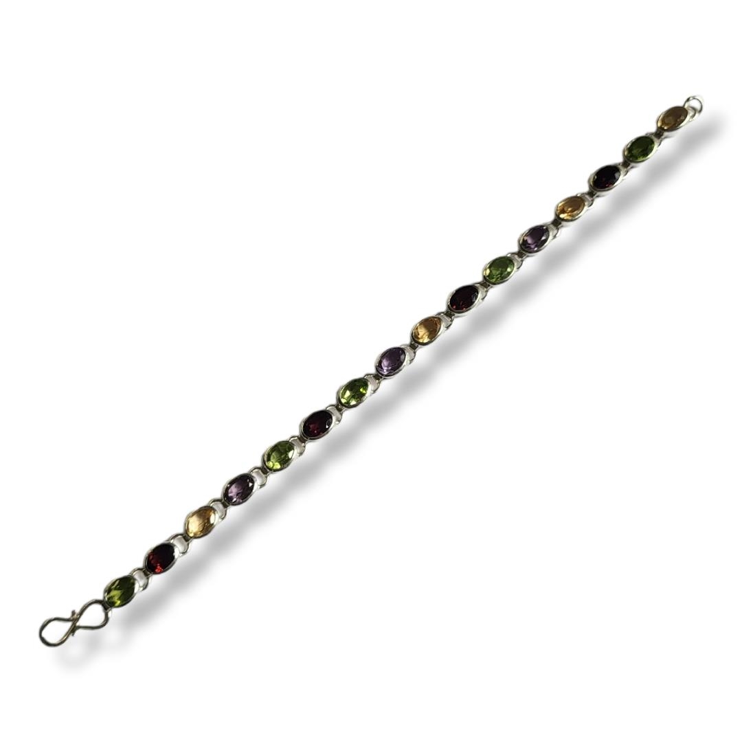 A WHITE METAL AND GEMSTONE 'TUTTI FRUTTI' BRACELET Having a row of oval cut stones including