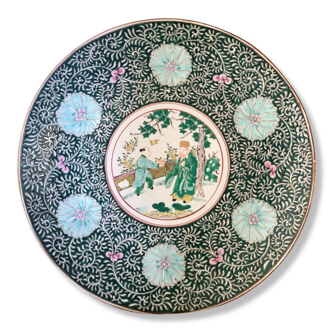 A LARGE CHINESE CHARGER Decorated with a court scene surrounded by flowers on a green ground,