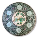 A LARGE CHINESE CHARGER Decorated with a court scene surrounded by flowers on a green ground,