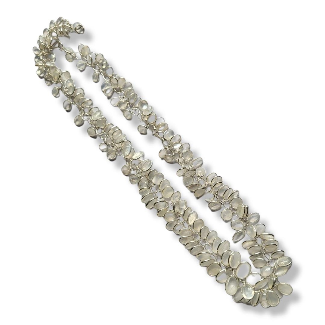 A WHITE METAL AND MOONSTONE CLUSTER NECKLACE The arrangement of oval cut moonstone on a plain