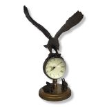 A BRONZE EAGLE BALL MANTEL CLOCK Having an eagle finial above a bullseye glass clock with mechanical