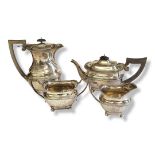 AN EARLY 20TH CENTURY FOUR PIECE SILVER TEA SET Plain form, with carved wooden handle and beaded