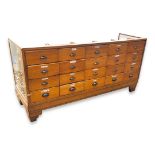 AN EARLY 20TH CENTURY OAK SHOP/HABERDASHERY COUNTER Fitted with twenty drawers, raised on odeon