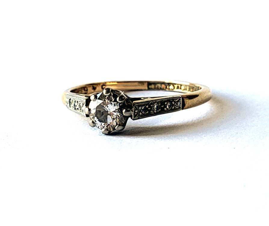 AN 18CT GOLD AND DIAMOND SOLITAIRE RING The round cut diamond with diamond set shoulders. (approx