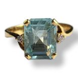 A 14CT GOLD AND AQUAMARINE RING The cushion cut central stone flanked by round cut diamonds. (aqua