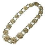 AN EARLY 20TH CENTURY SILVER FILIGREE NECKLACE Having floral form panels with fine chain link