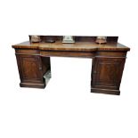 A LARGE GEORGIAN MAHOGANY BREAKFRONT SIDEBOARD With a single bow fronted drawer above two cupboards.