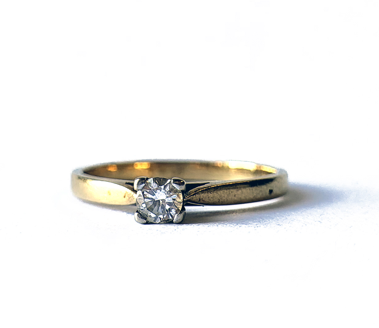 AN 18CT GOLD AND DIAMOND SOLITAIRE RING Set with a round cut diamond on a plain shank. (approx