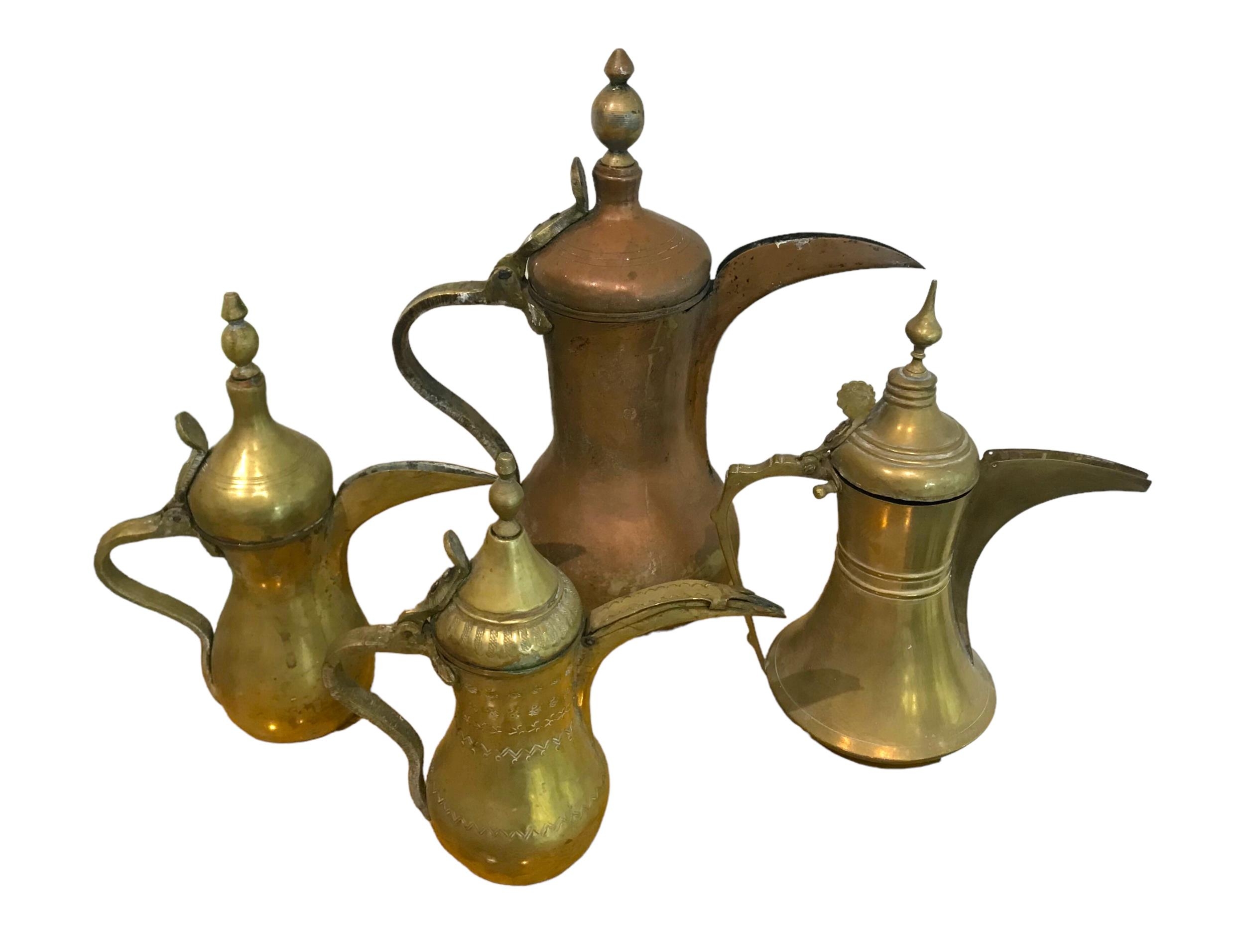 A COLLECTION OF FOUR 19TH/20TH CENTURY ISLAMIC COPPER AND BRASS DALLAH’S. (largest h 37cm x w 34.5cm