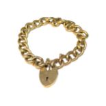 A YELLOW METAL CURB LINK CHARM BRACELET WITH PADLOCK CLASP. (tested for 9ct, 24.6g)
