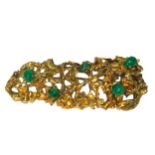 A YELLOW METAL AND EMERALD NATURALISTIC BROOCH. (tested for 18ct, h 23mm x w 59mm x depth 13mm,