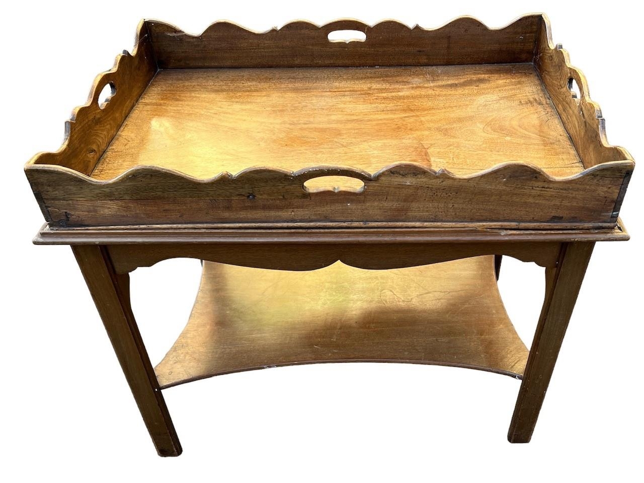 A 19TH CENTURY MAHOGANY BUTLER’S TRAY ON STAND Having shaped sides and pierced handles, raised on