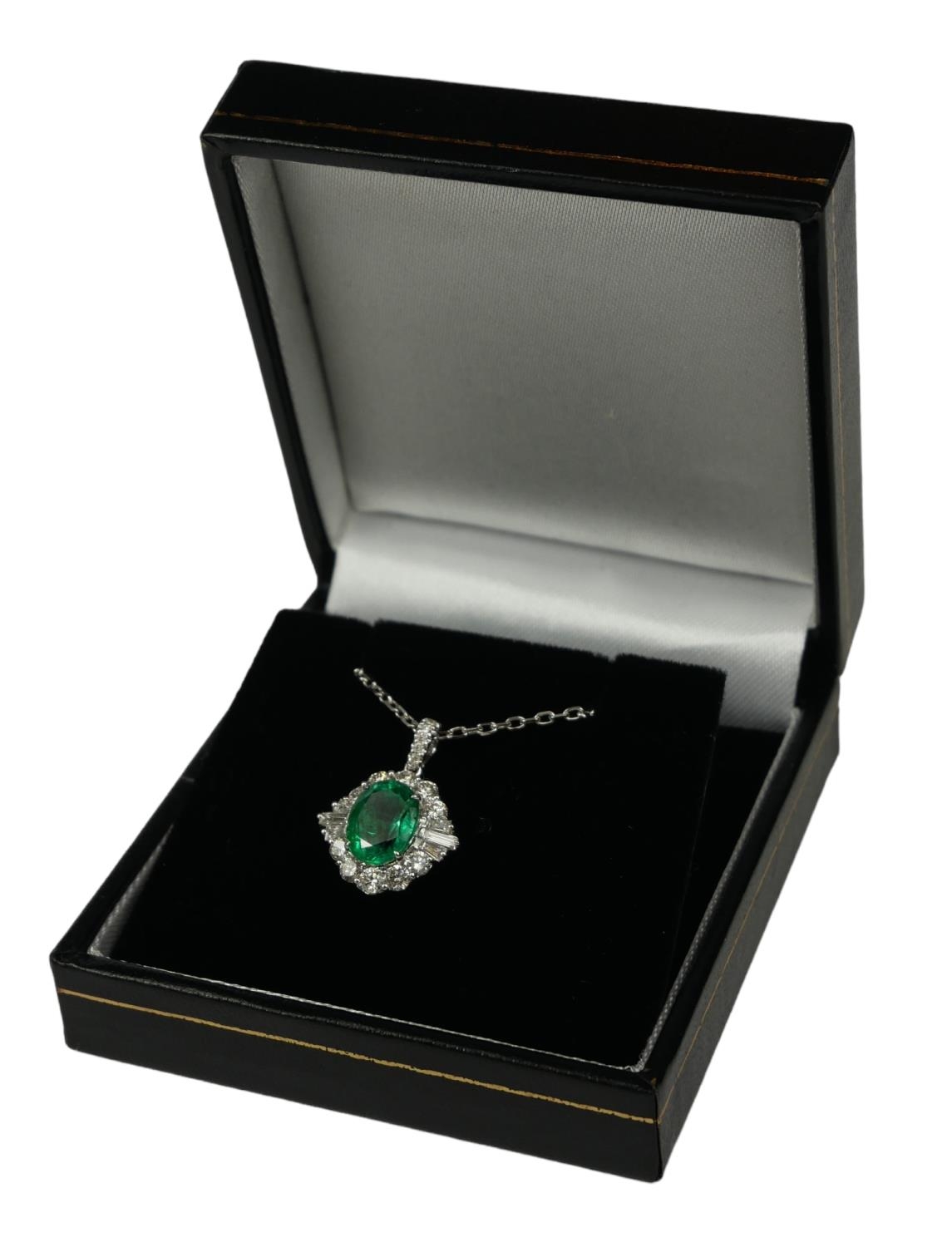 AN 18CT WHITE GOLD OVAL EMERALD AND DIAMOND CLUSTER PENDANT on an 18ct white gold chain. (Approx - Image 2 of 2