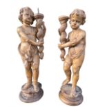 A PAIR OF 17TH/18TH CENTURY ITALIAN CARVED LIMEWOOD FIGURAL PRICKET CANDLESTICKS Two putti loosely