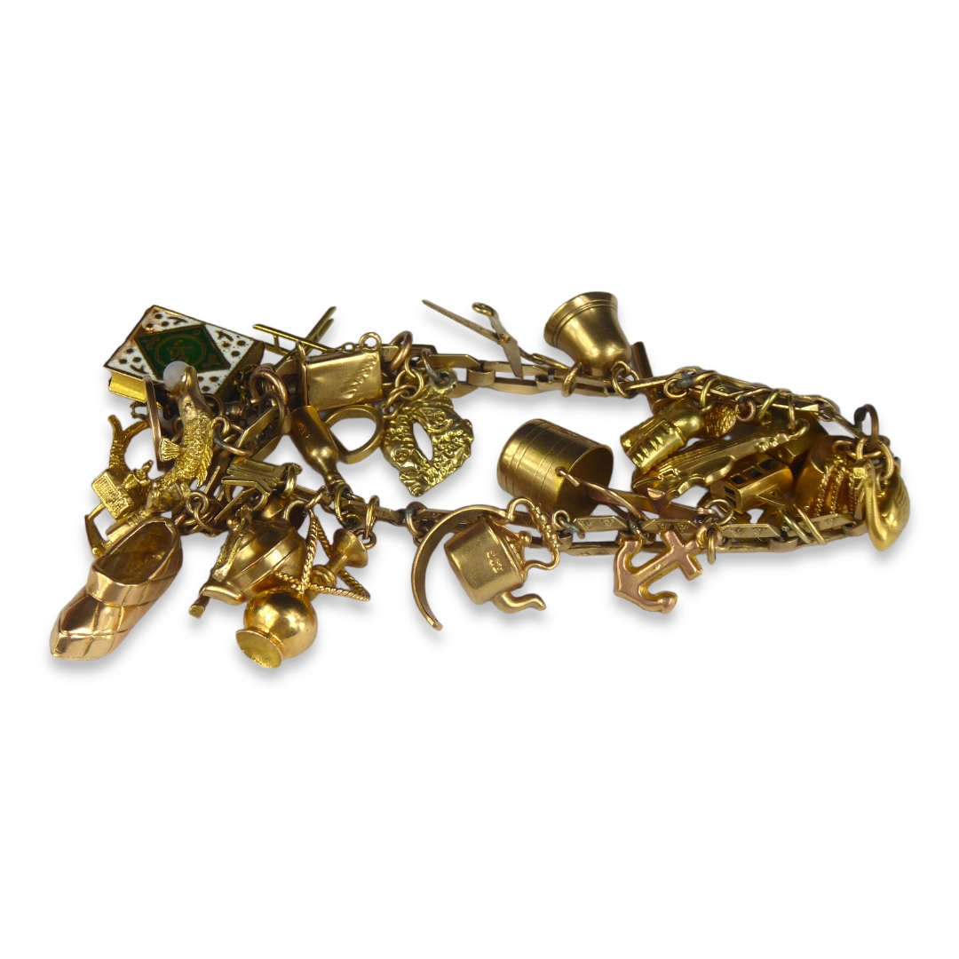 A 9CT GOLD CHARM BRACELET Hung with various 9ct gold charms including dice, a revolver, cello, - Image 2 of 3