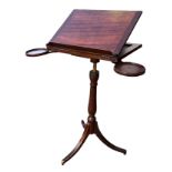 A 19TH CENTURY REGENCY MAHOGANY ADJUSTABLE TRIPOD MUSIC/READING STAND With a pair of candle holders.
