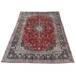 A LARGE PERSIAN RED GROUND CARPET With stylised floral geometrical pattern. (324cm x 251cm)