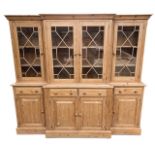 A LARGE VICTORIAN DESIGN WAXED PINE BREAKFRONT BOOKCASE The aster glazed doors opening to reveal a