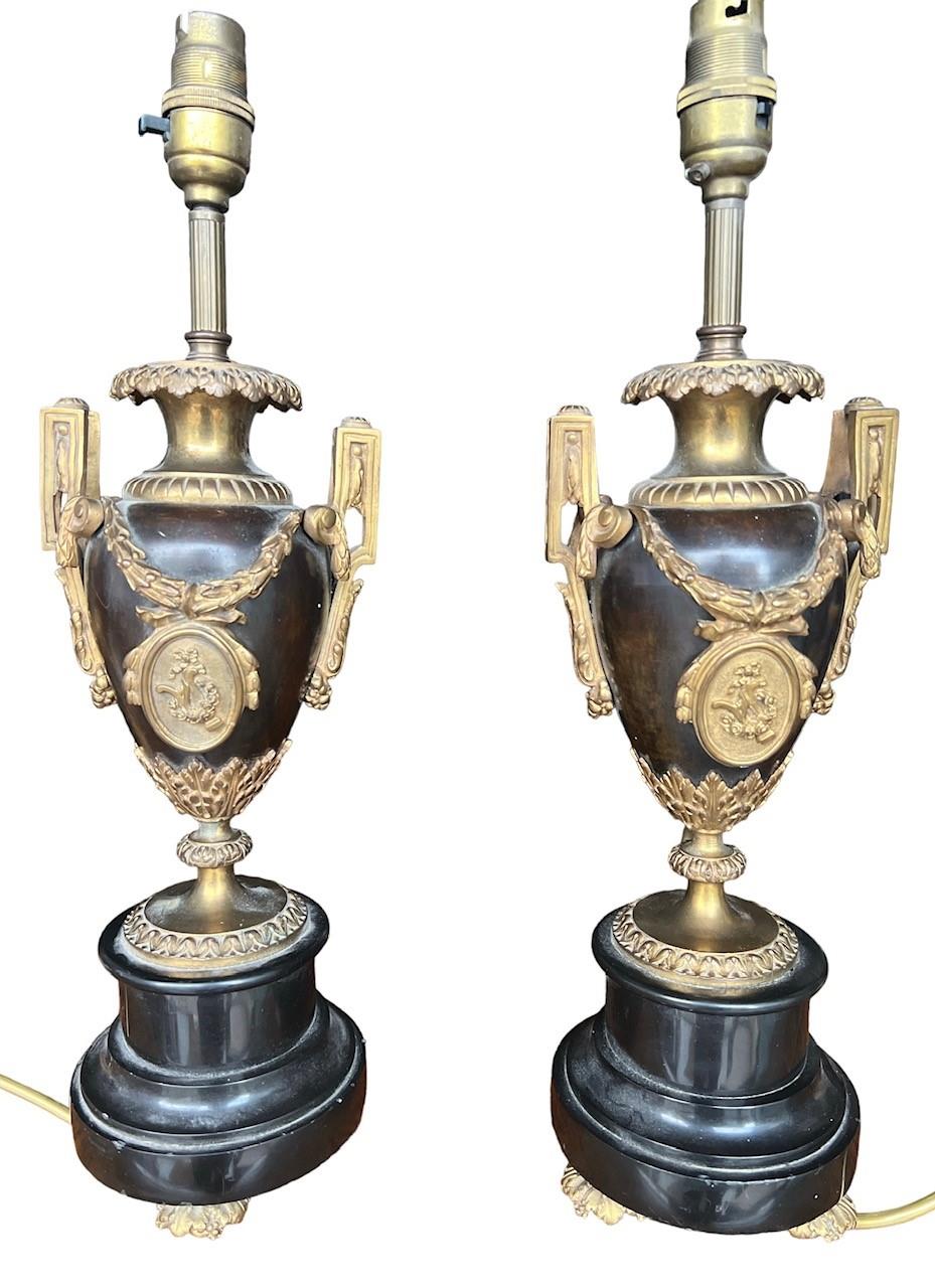 A PAIR OF LATE 19TH CENTURY FRENCH GILT BRONZE TWIN HANDLED URNS Decorated with acanthus leaf and