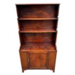 A 19TH CENTURY MAHOGANY WATERFALL BOOKCASE With single cupboard door, raised on bracket feet. (h