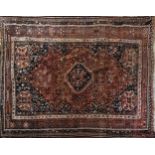 AN INDIAN/PERSIAN WOOLLEN RUG Woven with exotic birds and scrolls on a lozenge form central field on