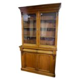 A VICTORIAN MAHOGANY BOOKCASE With two glazed doors above cushion drawers and cupboards. (120cm x
