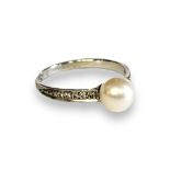 AN 18CT GOLD PEARL AND DIAMOND RING Having a single pearl with round cut diamonds to shoulders, in a