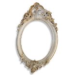 A 19TH CENTURY FRENCH OVAL MIRROR With carved and pierced floral cartouche above a planished