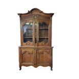 A 19TH CENTURY FRENCH PROVINCIAL PITCH PINE DRESSER With carved cornice above ogee glazed doors