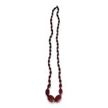 A VICTORIAN CHERRY AMBER NECKLACE Having a single row of oval cut beads. (approx 79cm) Condition: