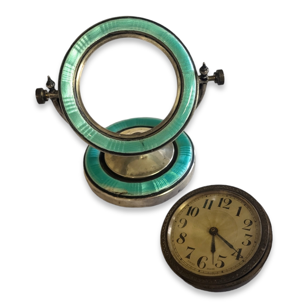 AN EDWARDIAN SILVER AND GUILLOCHE ENAMEL DRESSING CIRCULAR TABLE CLOCK With turquoise enamel and