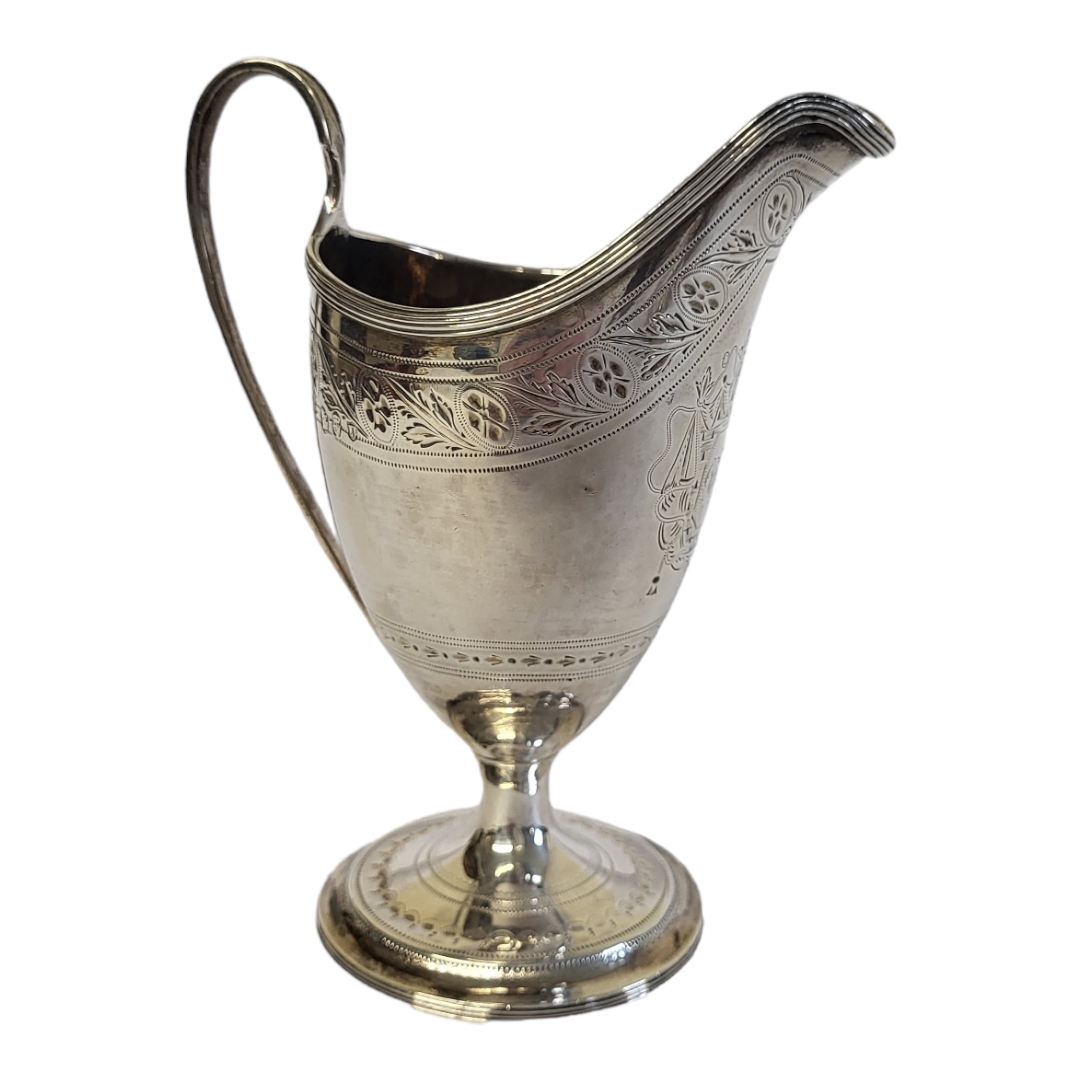 A GEORGIAN IRISH SILVER CREAM JUG Classical helmet form with engraved decoration and the initials ‘ - Image 3 of 4