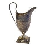 A GEORGIAN SILVER CREAM JUG Classical helmet form with engraved decoration and square base,