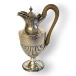 A GEORGIAN SILVER CLASSICAL CLARET JUG With carved wooden handle and reeded flutes to body,