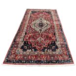 A LARGE PERSIAN RED GROUND CARPET With stylised floral pattern. (380cm x 208cm)